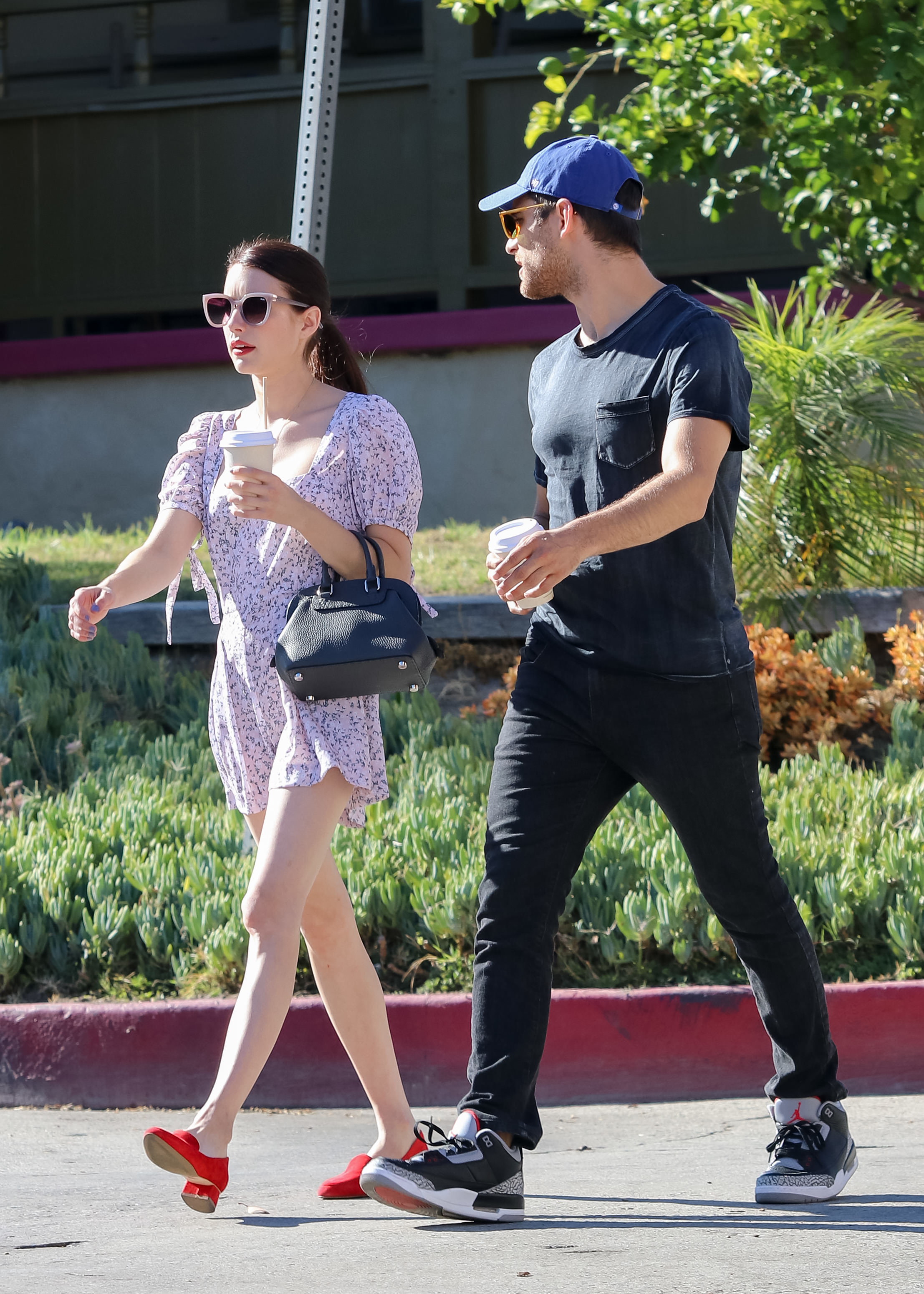 Emma holds a coffee cup as she walks with Cody