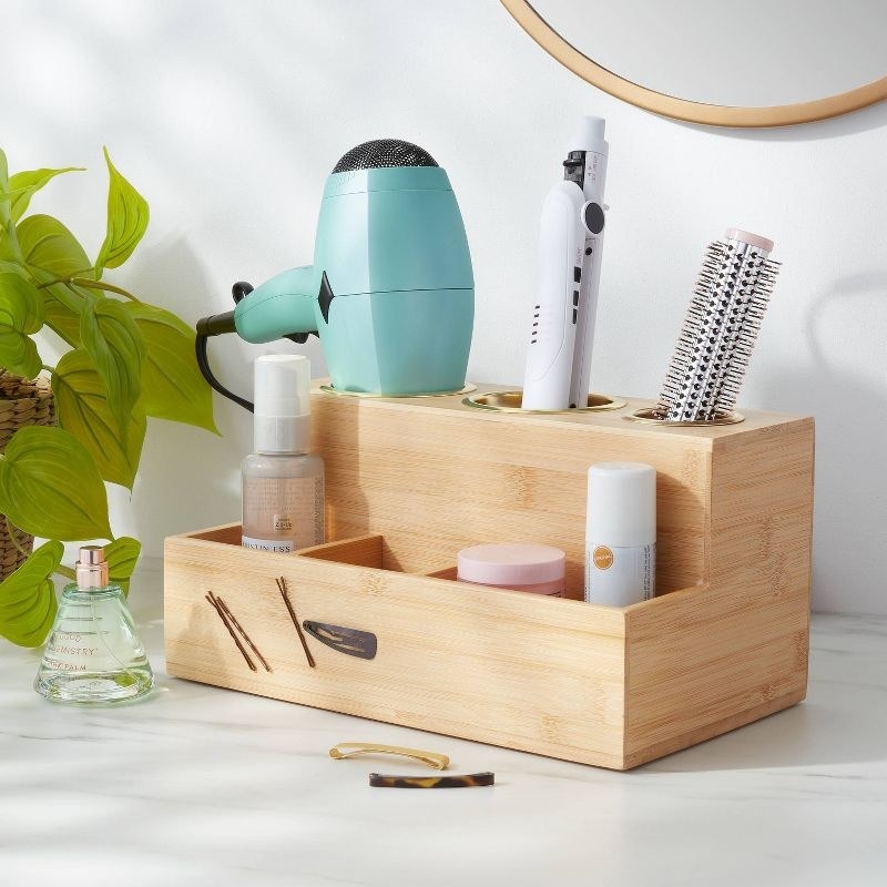 Wooden hot tools organizer with various hot hair tools and hair products in it