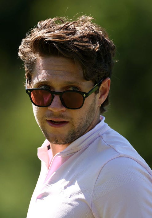 A closeup of Niall as he looks over his tinted sunglasses