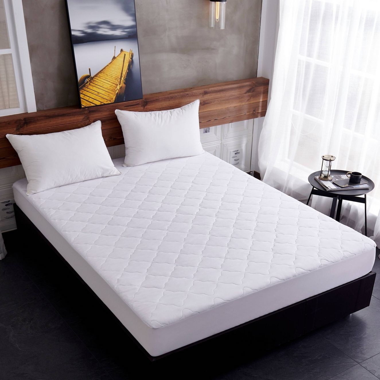 a white bed with the white mattress pad on top