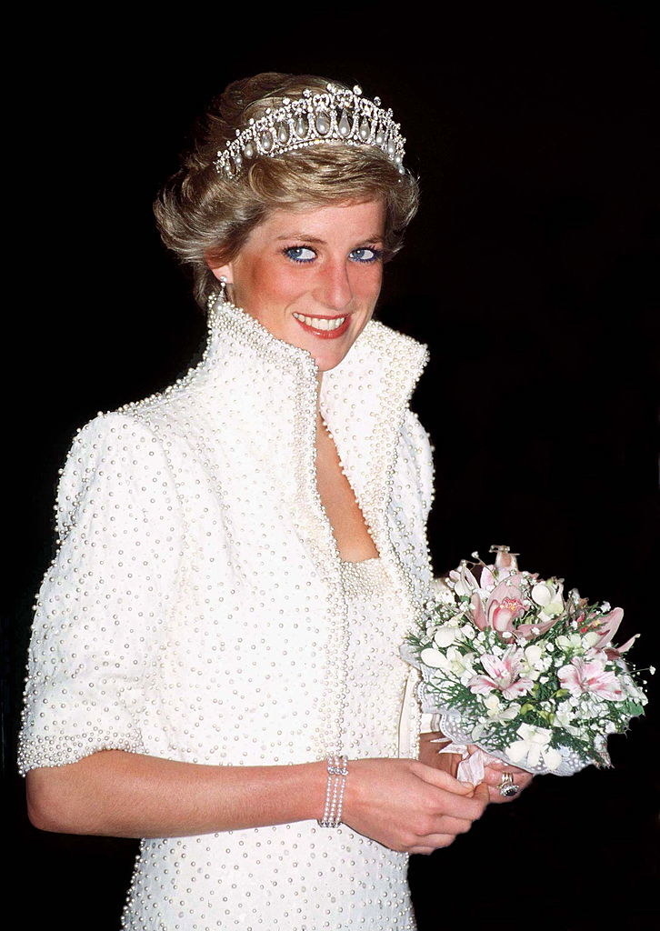 closeup of Diana wearing a tiara and holding a bouquet of flowers