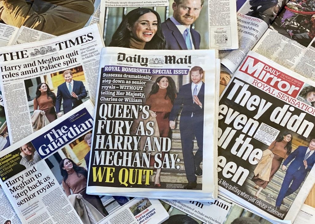 pile of newspapers with meghan and harry on the front page