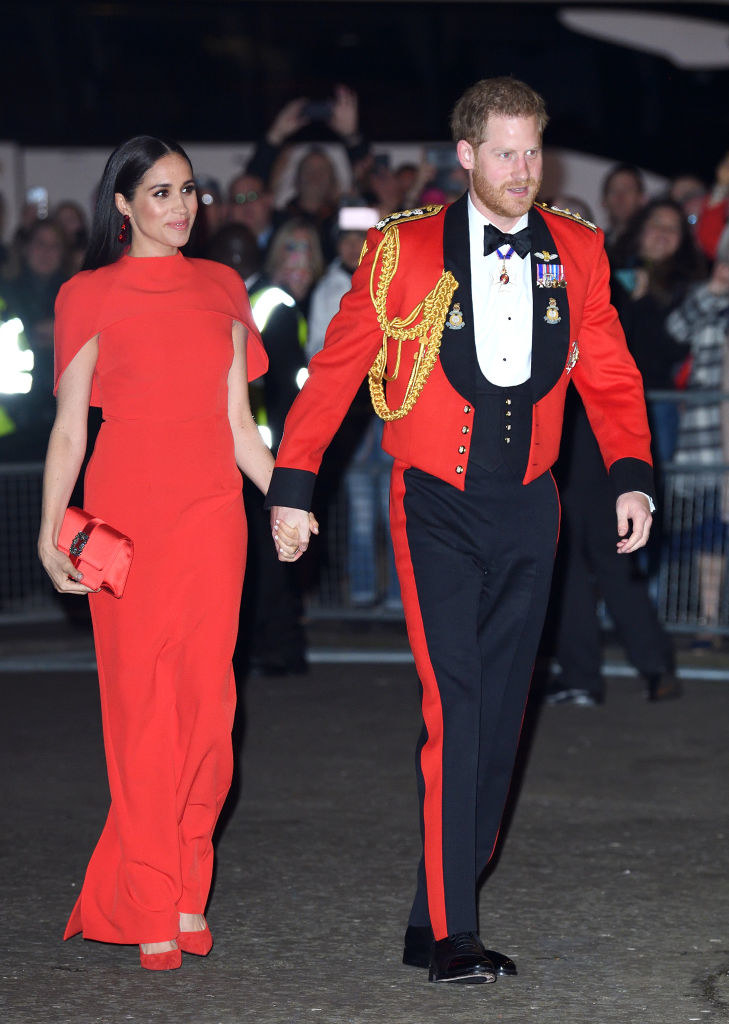 Meghan and Harry holding hands as they walk to a royal event