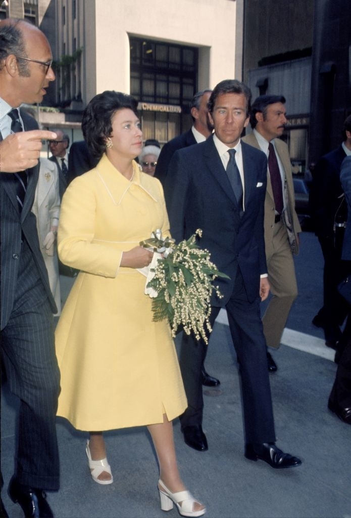 margaret walking with a group of men holding flowers