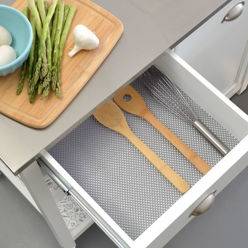The liner in a drawer with utensils on top
