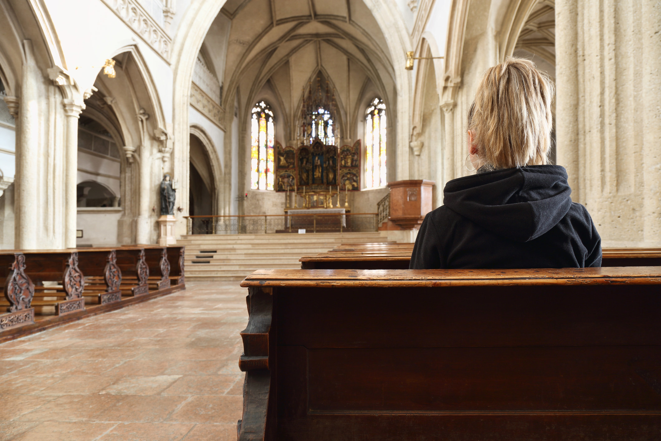 A person sitting in an otherwise-empty church