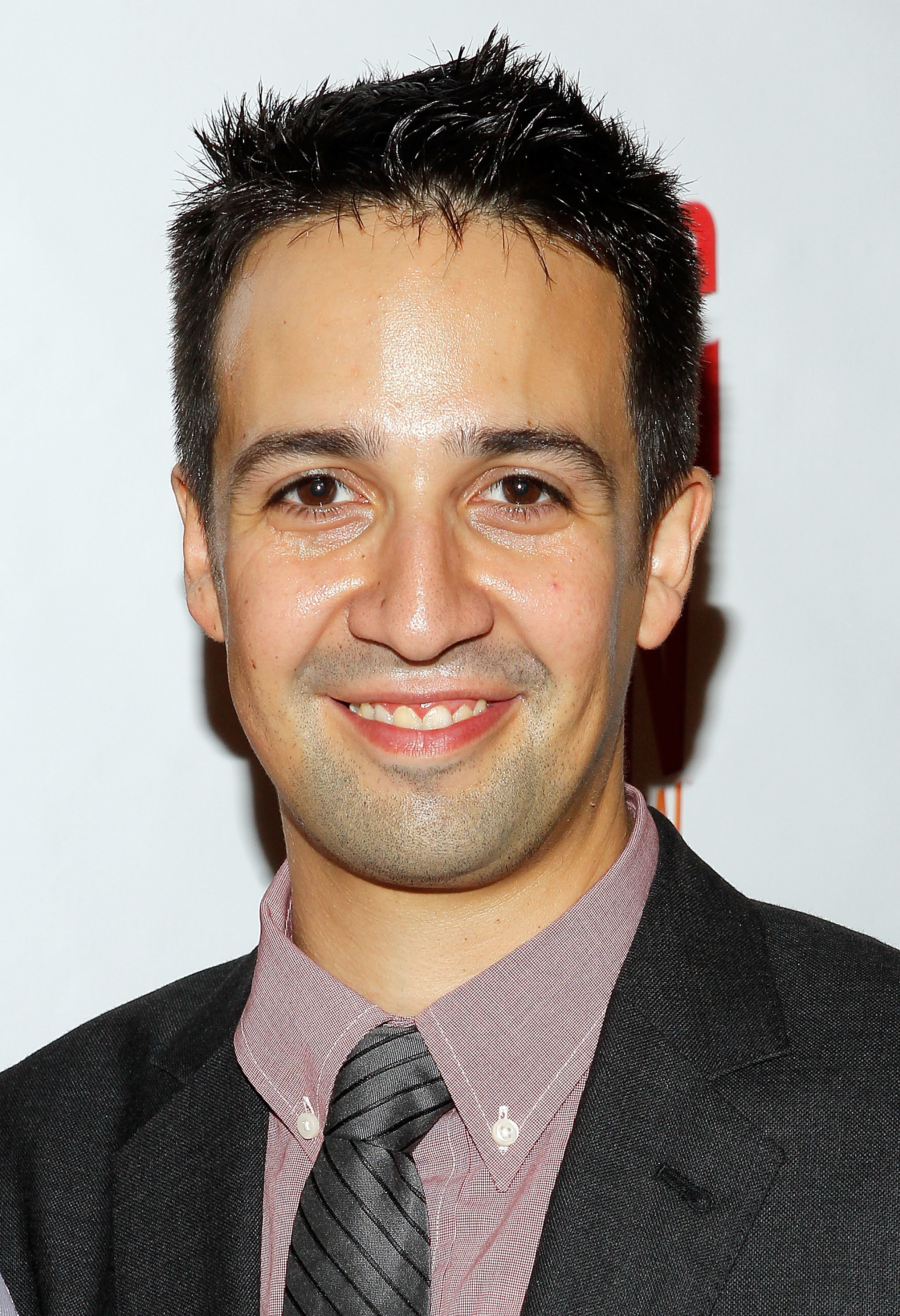 closeup of Lin-Manuel smiling with short spiky hair