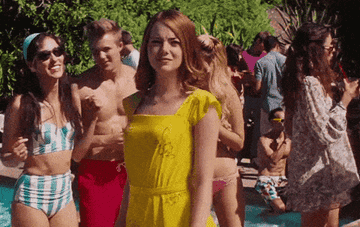 A woman in yellow dress points to herself