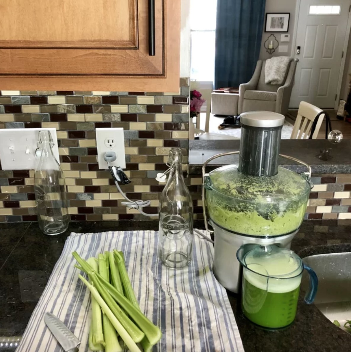 a juicer and cut celery on a kitchen countertop