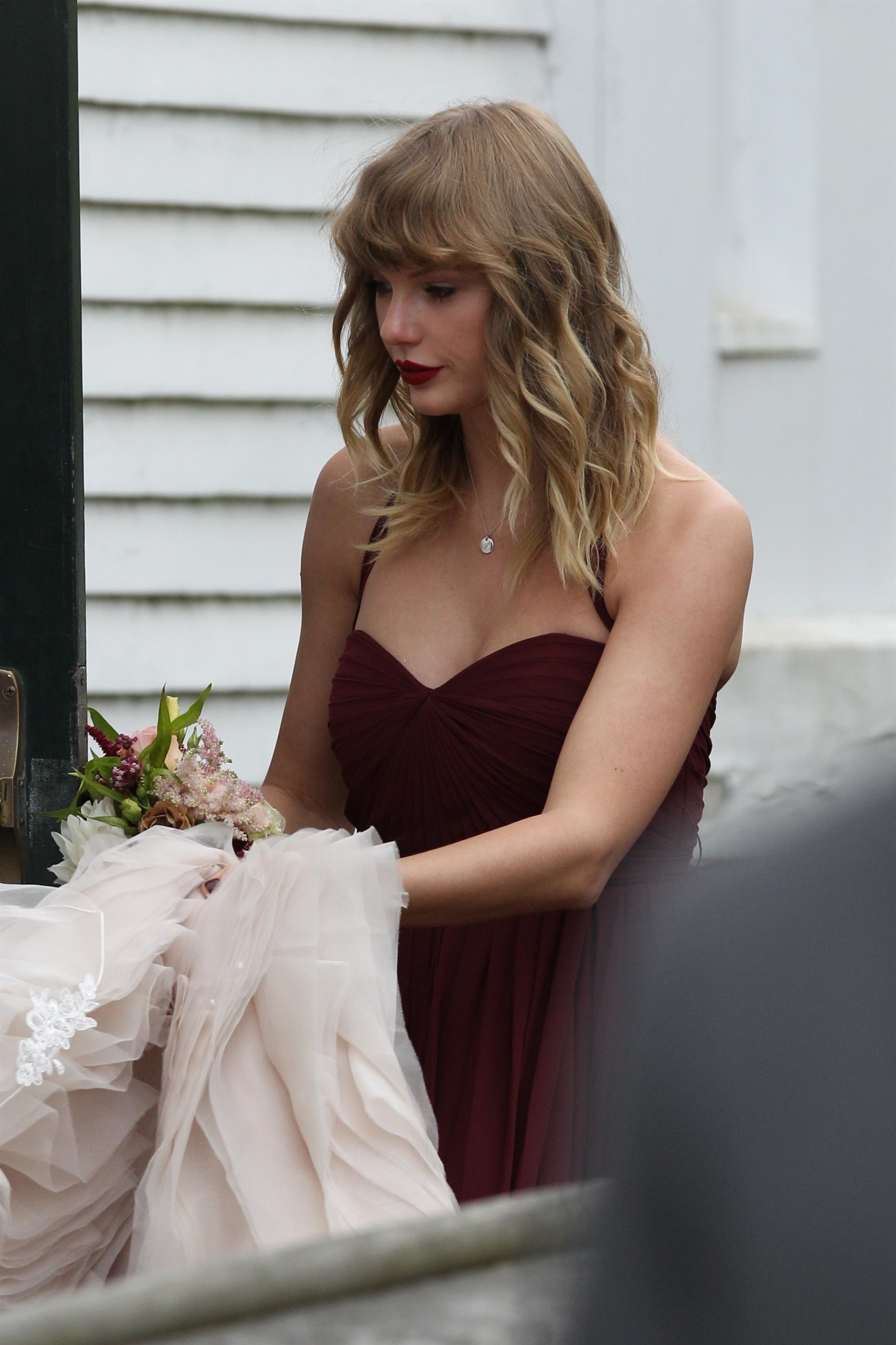 Taylor holding a bouquet and a wedding dress