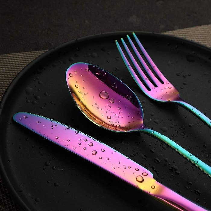 a knife, spoon, and fork on a plate with water droplets on them