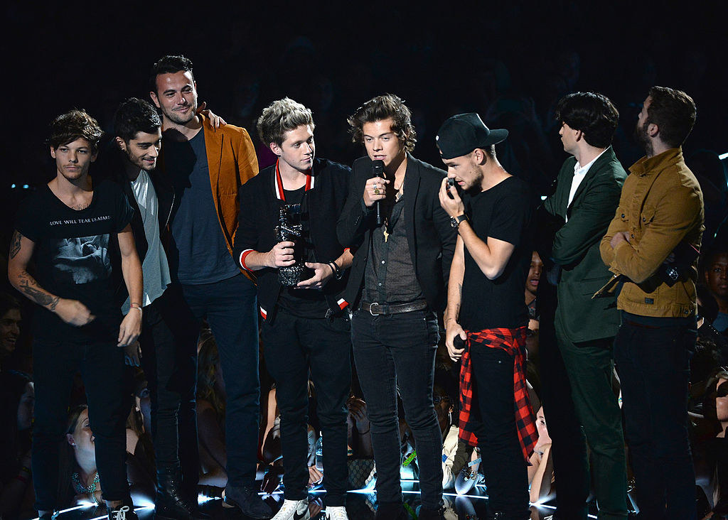 1D onstage, with Harry speaking into a microphone