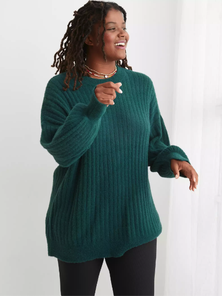 a model in a soft blue ribbed sweater