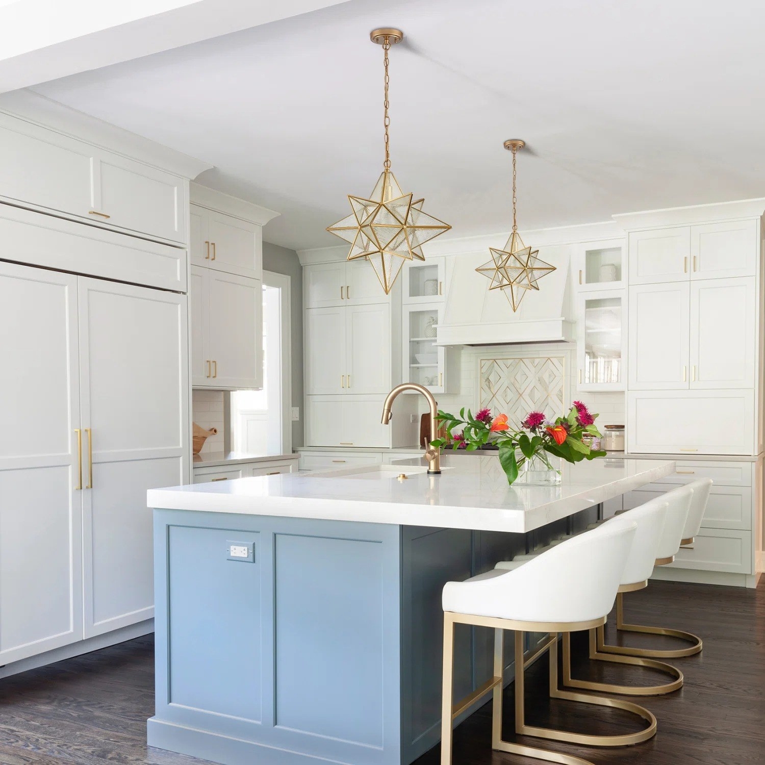 the gold and glass star pendant lights over a kitchen island