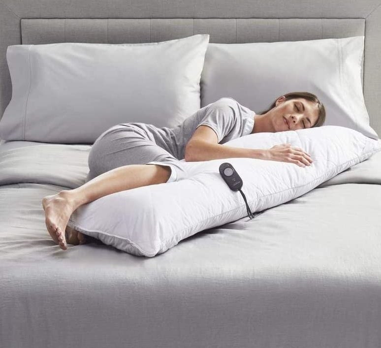 person hugging the heated pillow