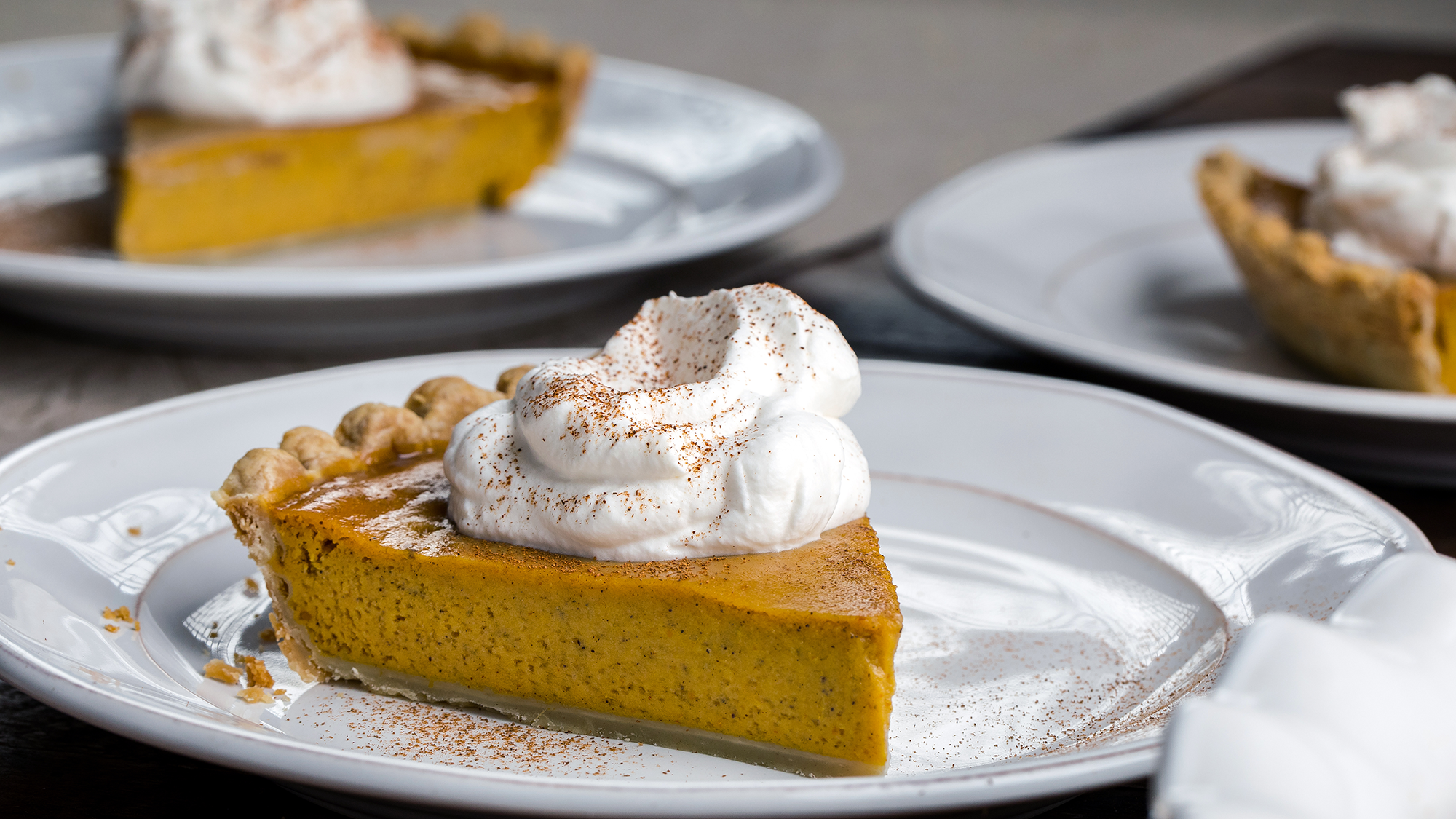 A slice of yummy pumpkin pie with whipped cream