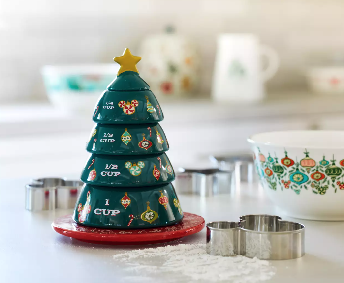 measuring cups stacked to look like a christmas tree with mickey mouse peppermints on it and ornaments