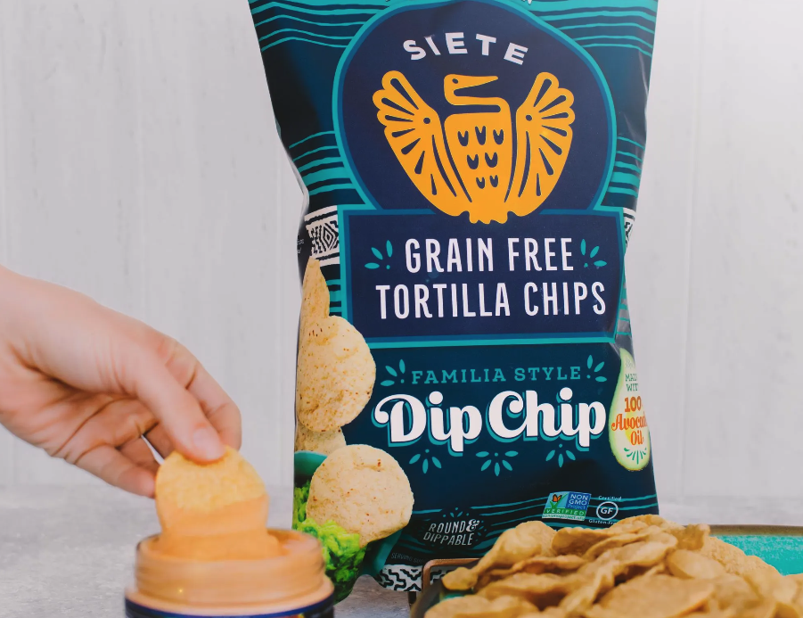 Grain Free Tortilla Chips being dipped in cheese