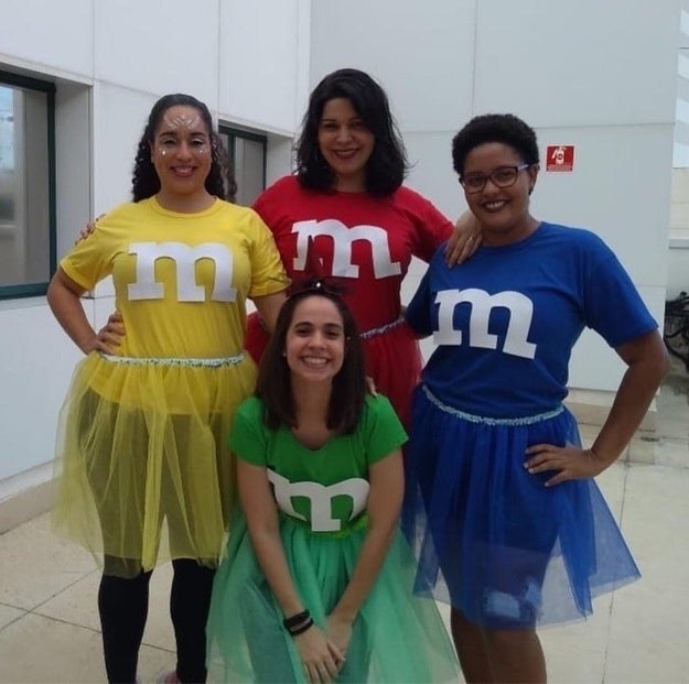 Four women dressed in colorful shirts with the M&amp;amp;M&#x27;s logo on top