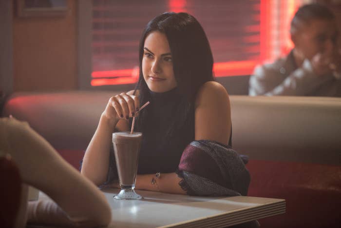 Camila's character drinking a milkshake in a diner
