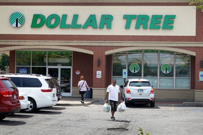 Customers walking through the parking lot of a Dollar Tree store