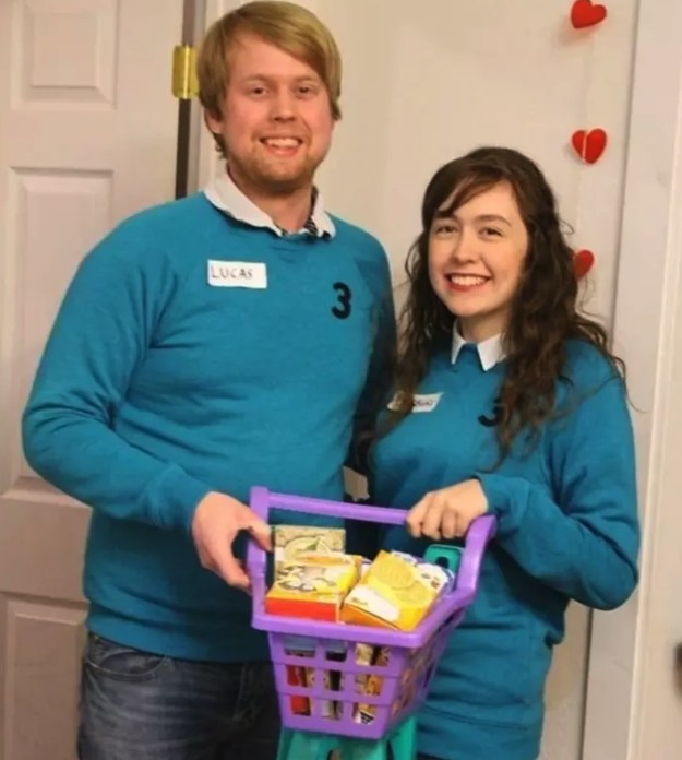 two people in sweaters holding a shopping cart