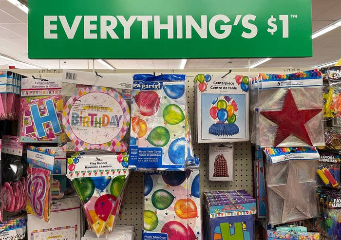 An array of party supplies with a sign above that says &quot;everything&#x27;s $1&quot;