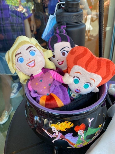 a cauldron with the three stuffed dolls