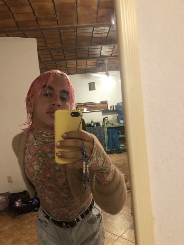the same person wearing a floral turtleneck with a cardigan and dyed pink hair