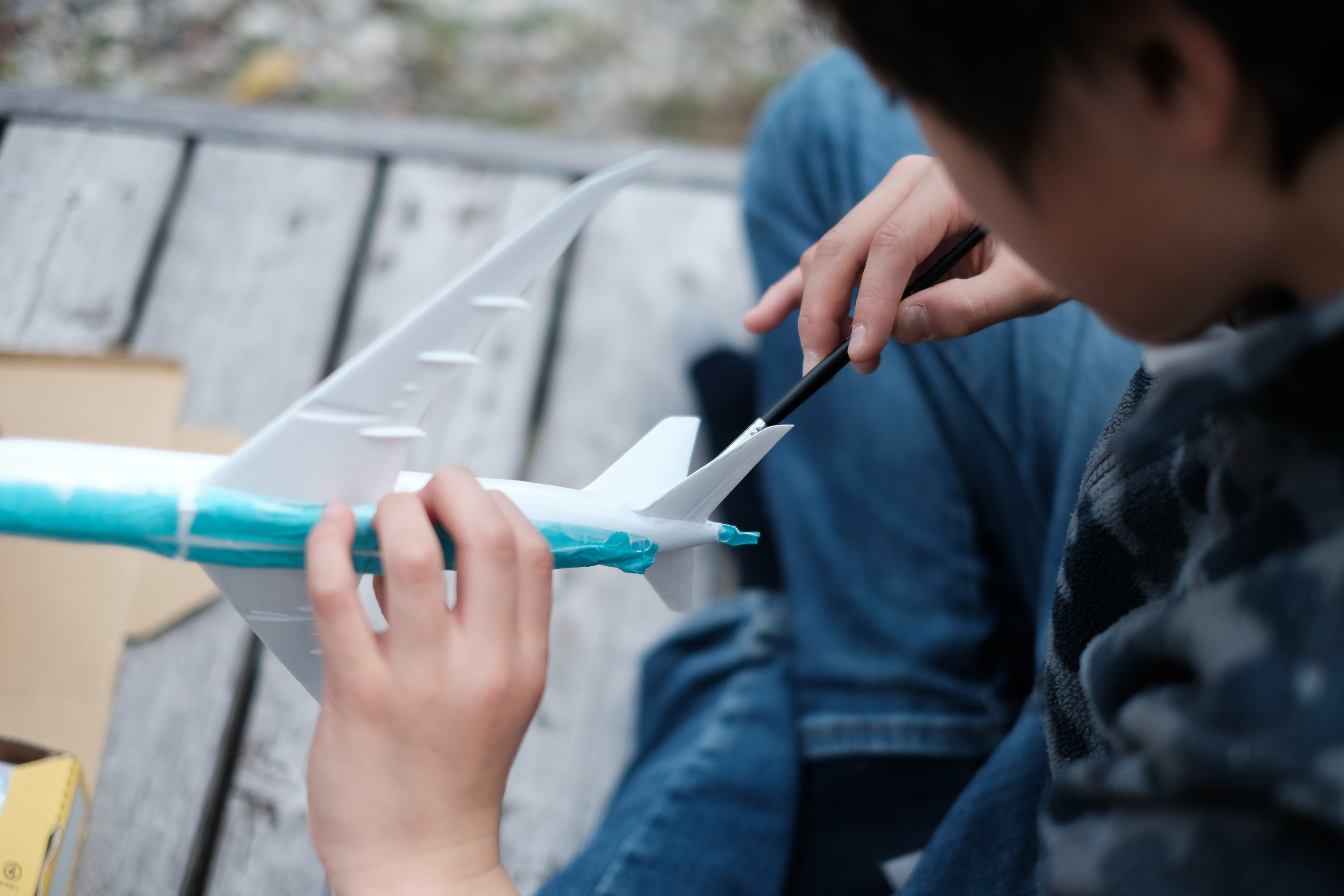 kid painting model airplane