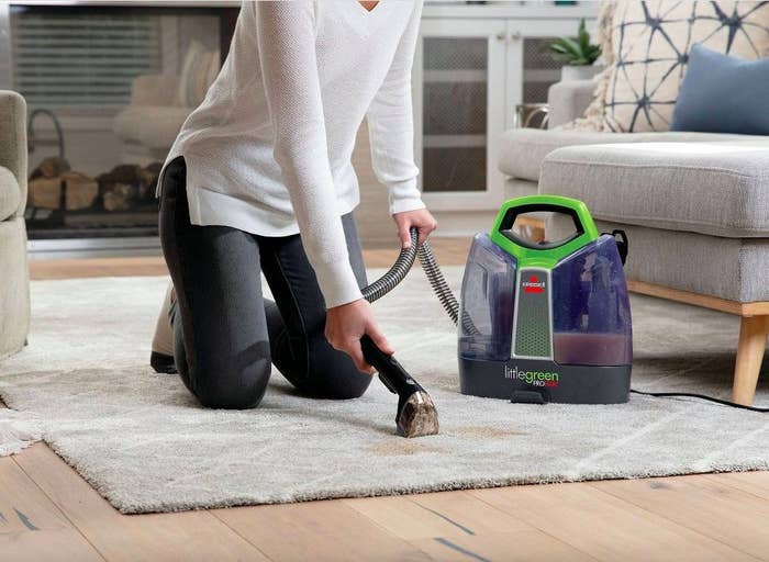 A woman using the machine on a rug