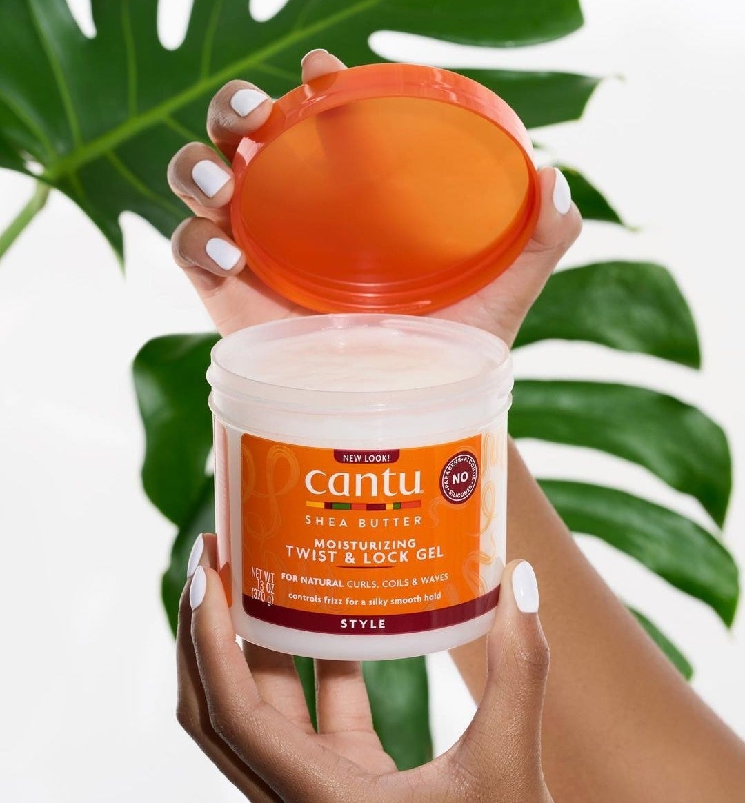 a hand holding the container of gel