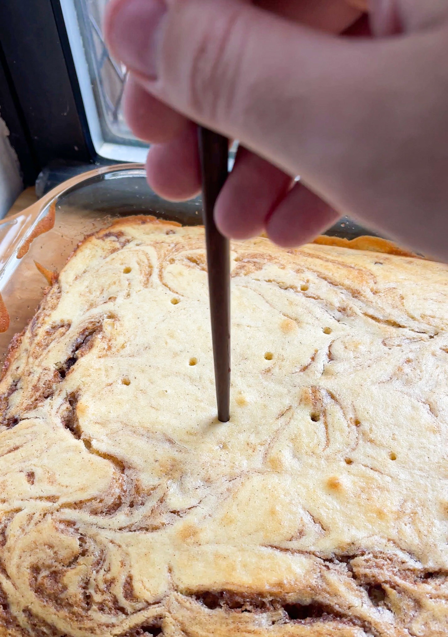 poking holes in the cake with a chopstick