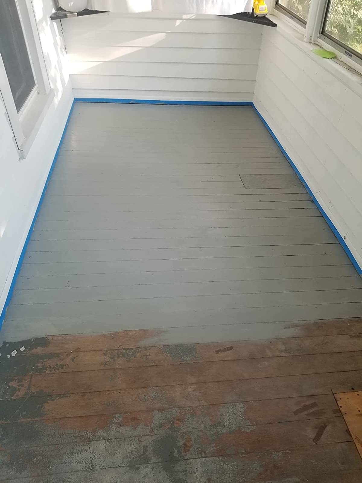 a reviewer&#x27;s wood deck that&#x27;s faded and is half painted over with gray paint