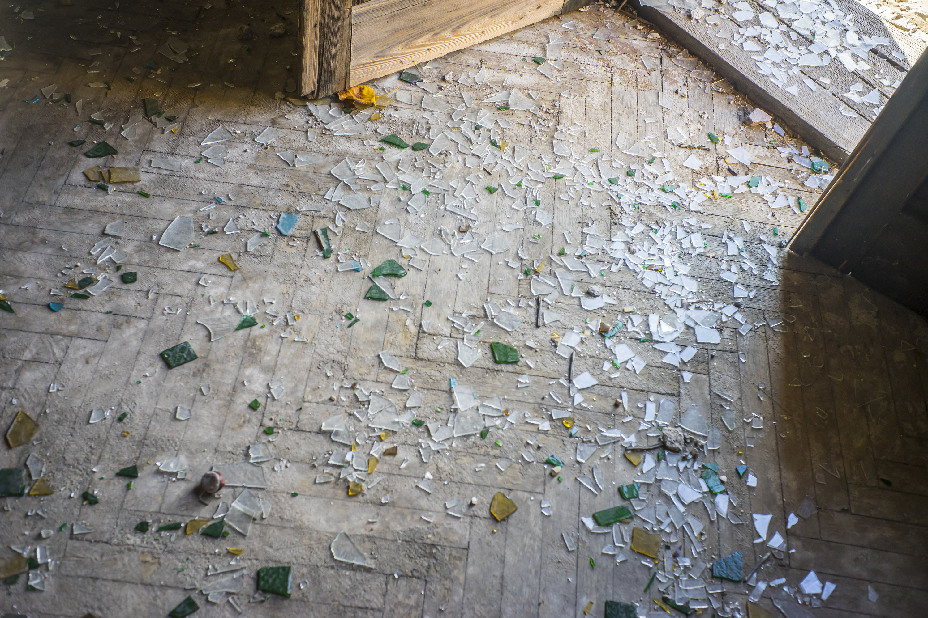 broken glass from a door on the floor inside a doorway