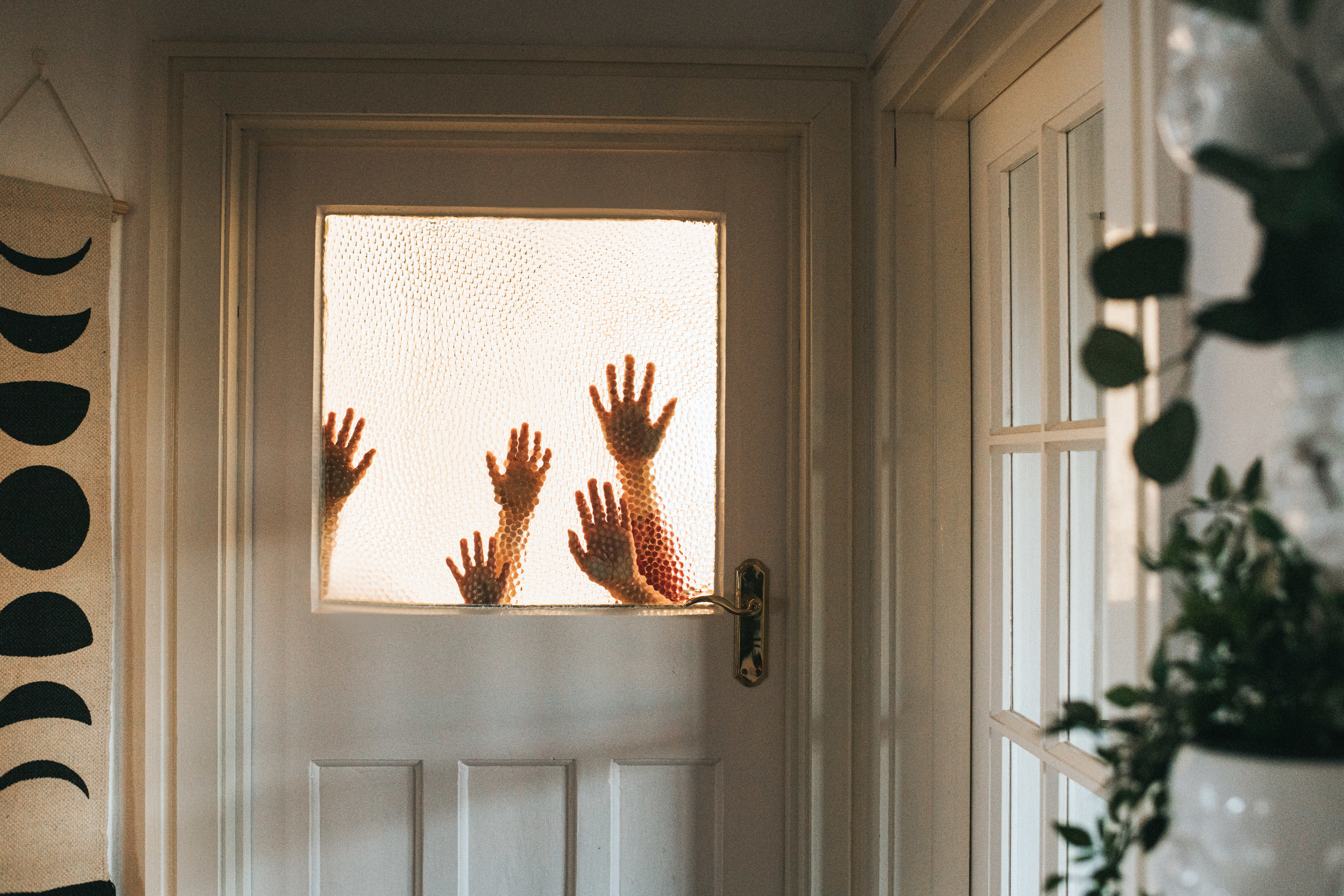 hands against the window of a door