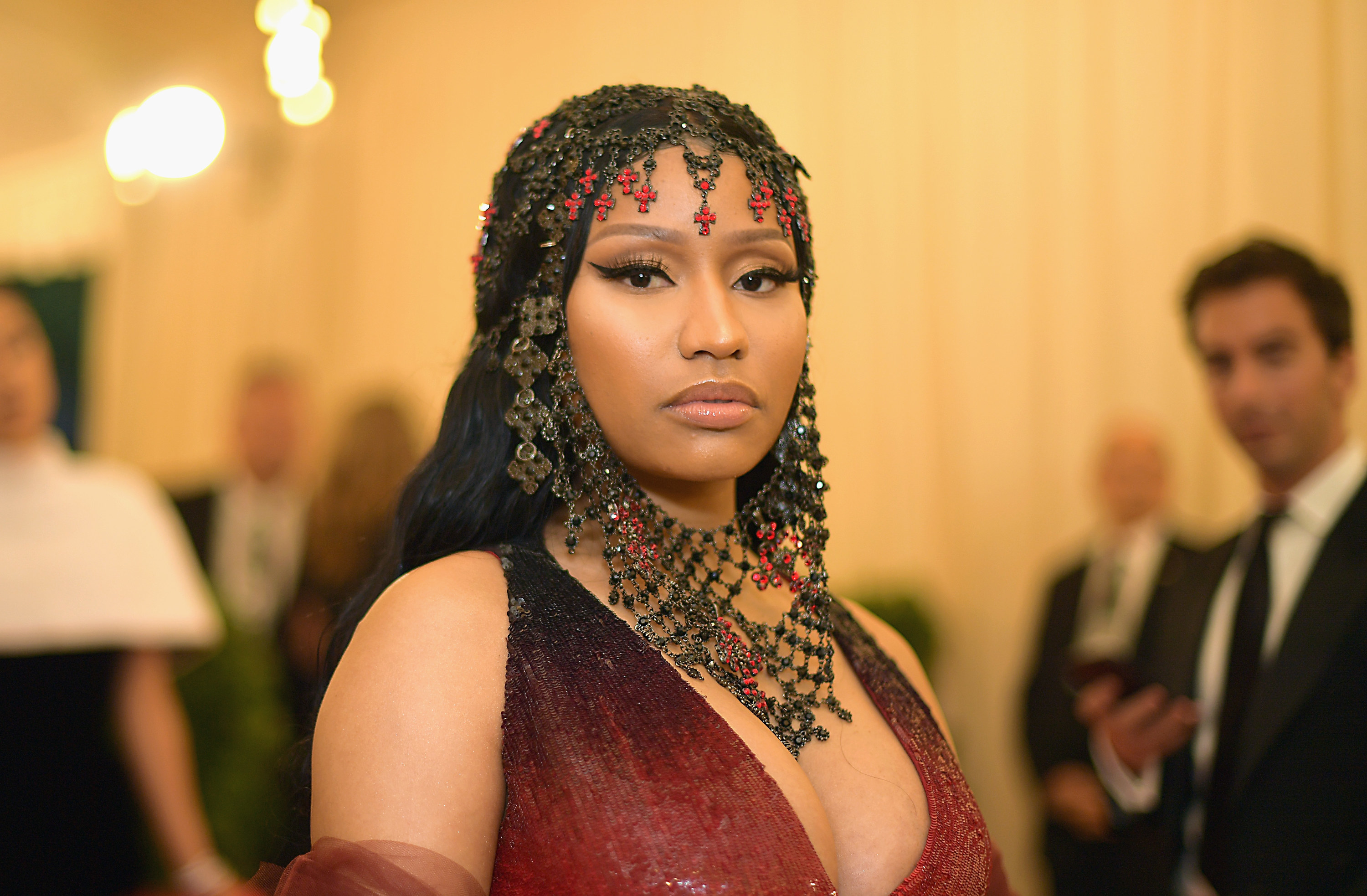 A closeup of Nicki at the MET Gala in an ombre gown and matching headpiece