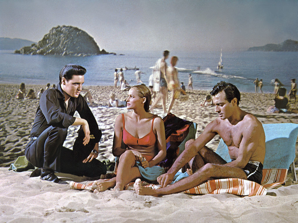elvis in the movie on a beach with two other people