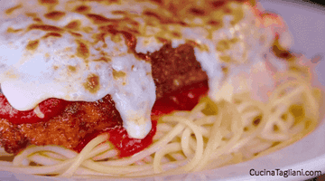 close up of chicken parmesan over spaghetti