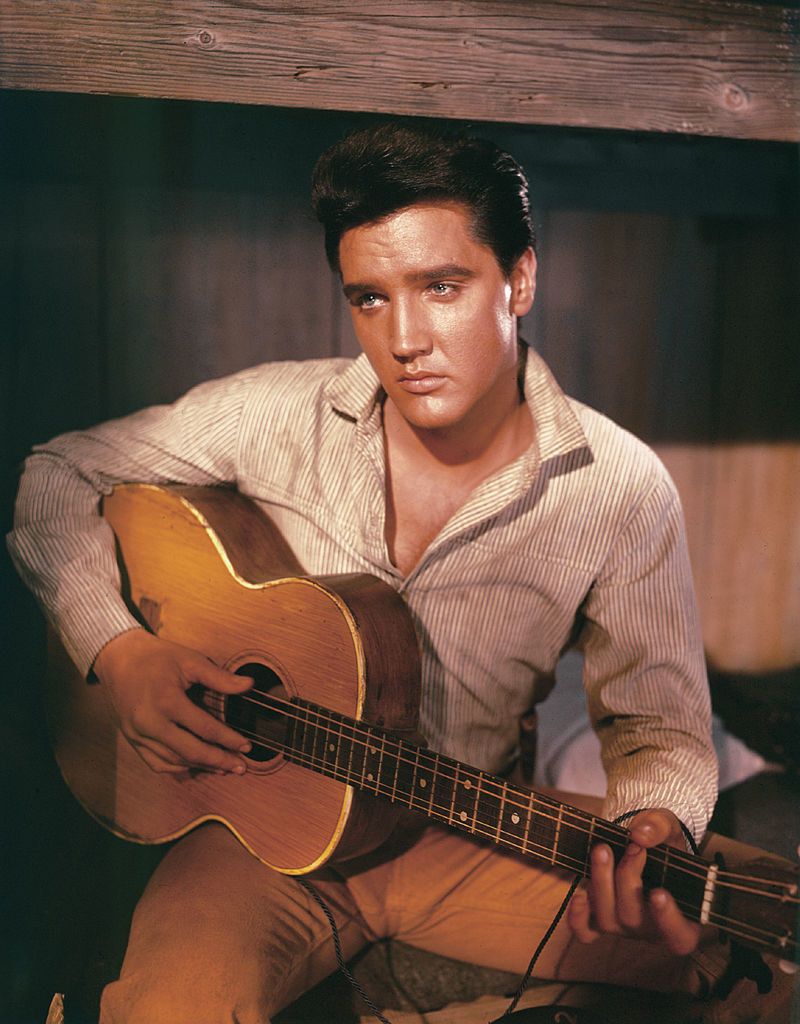 Elvis sitting down with a guitar