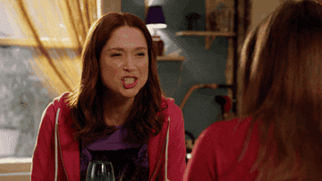a gif of ellie kemper as kimmy schmidt saying you rock to her reflection