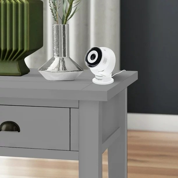 A white camera on a grey desk