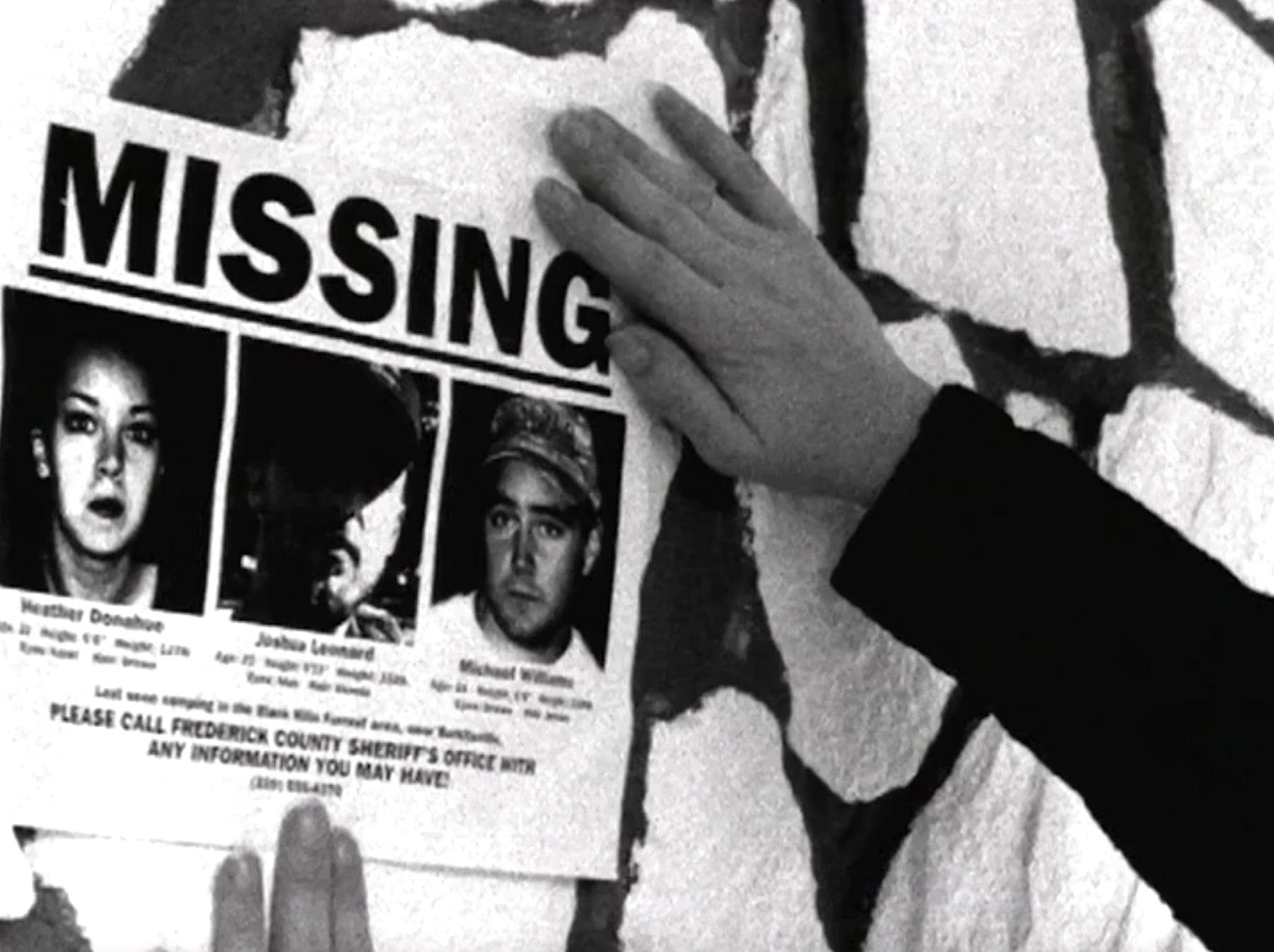 Someone putting up a &quot;Missing&quot; poster