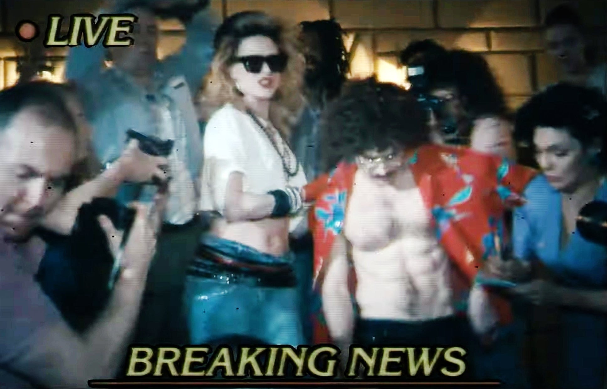 Al and Madonna shown on the news being mobbed by paparazzi as they walk out of a building in a scene from the film