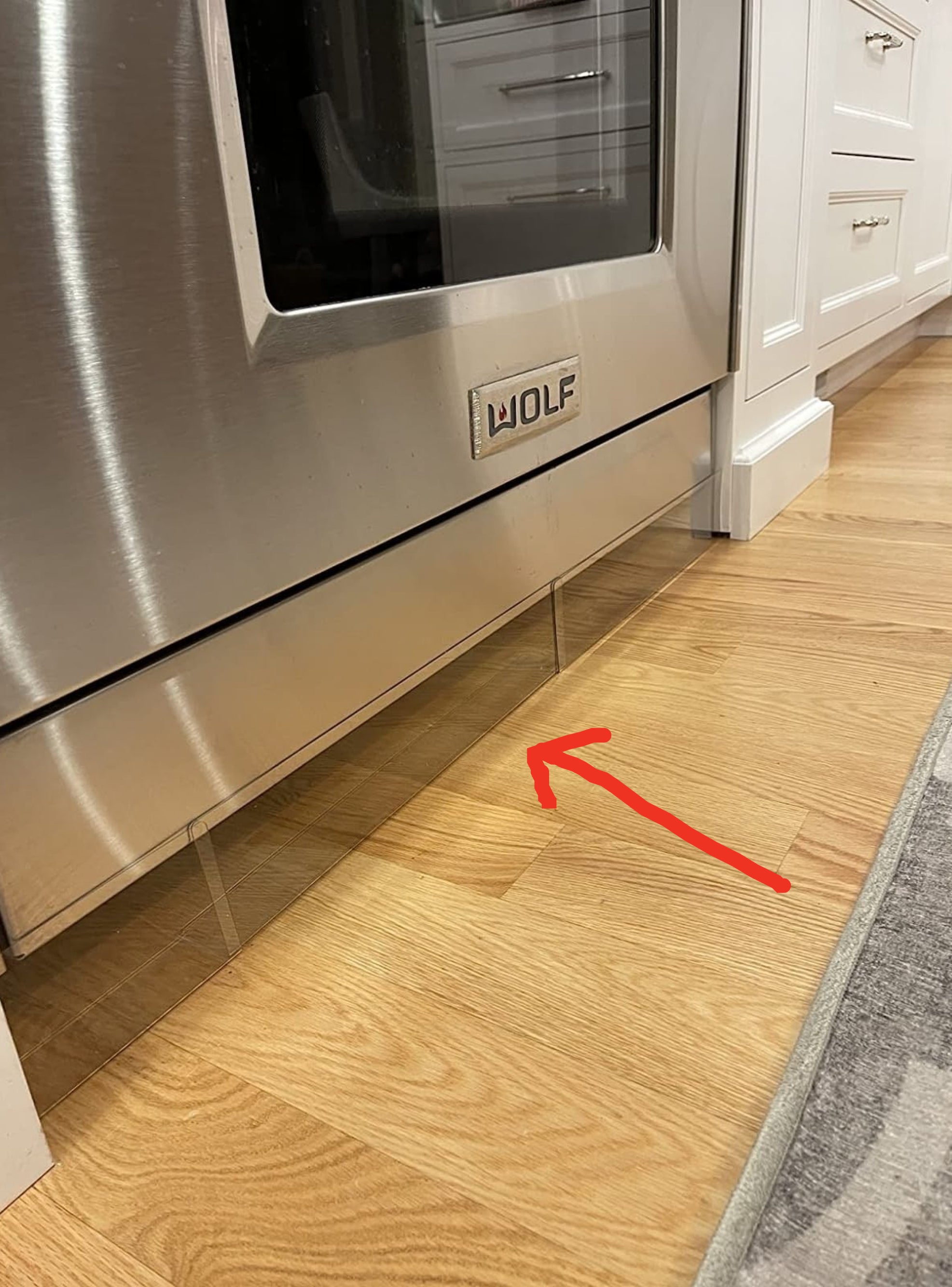 Reviewer&#x27;s oven with the clear blockade under it and a red arrow pointing to it