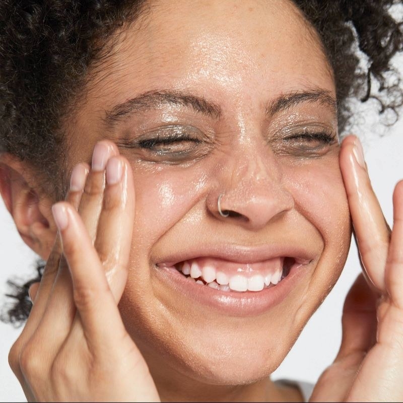 A person using a cleansing balm on their skin