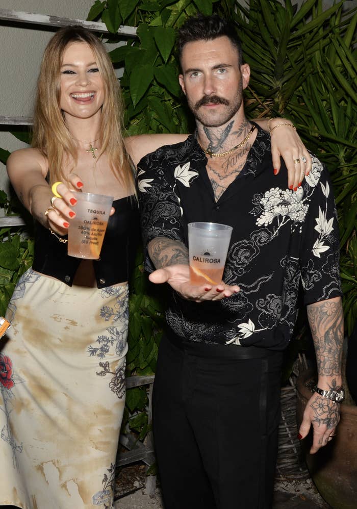 behati and adam drinking at an event