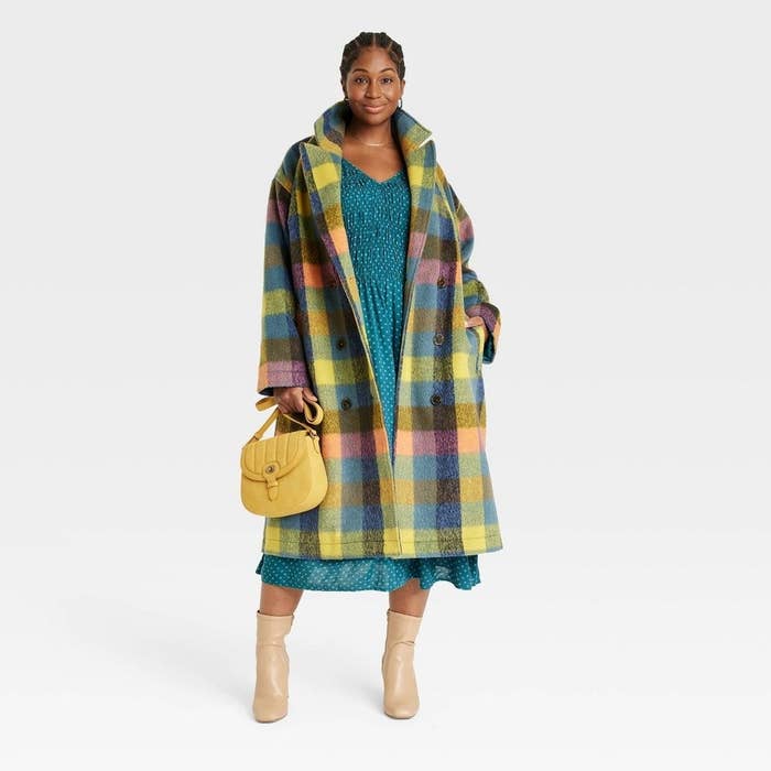 model wearing the green, blue and yellow plaid overcoat