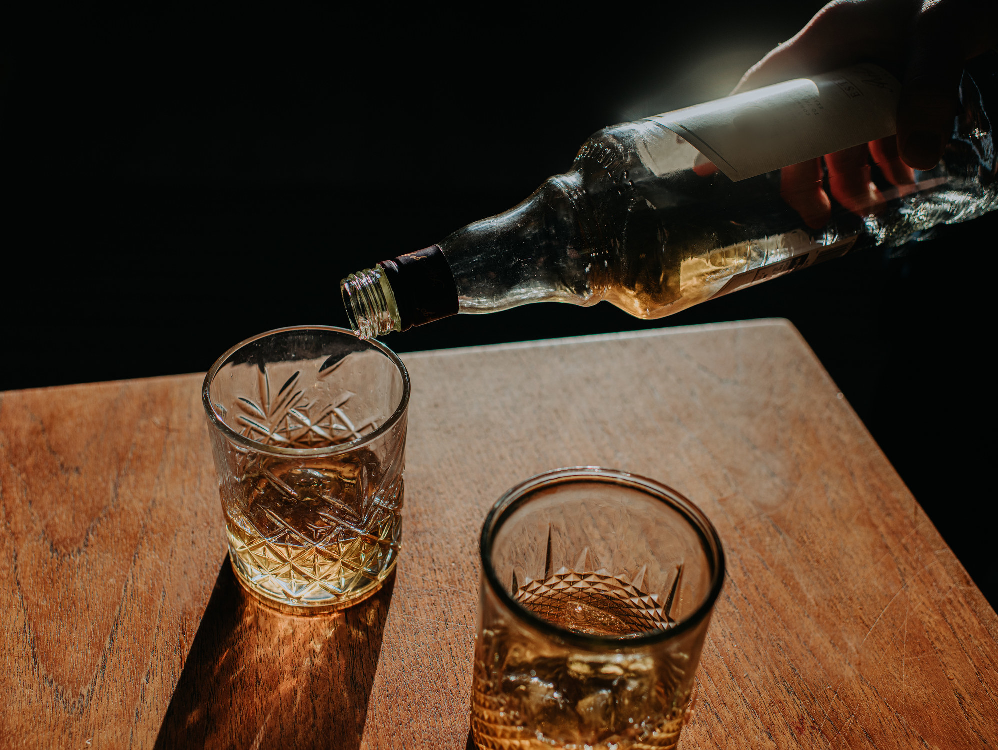 Whisky Pour from a bottle into a cut glass tumbler