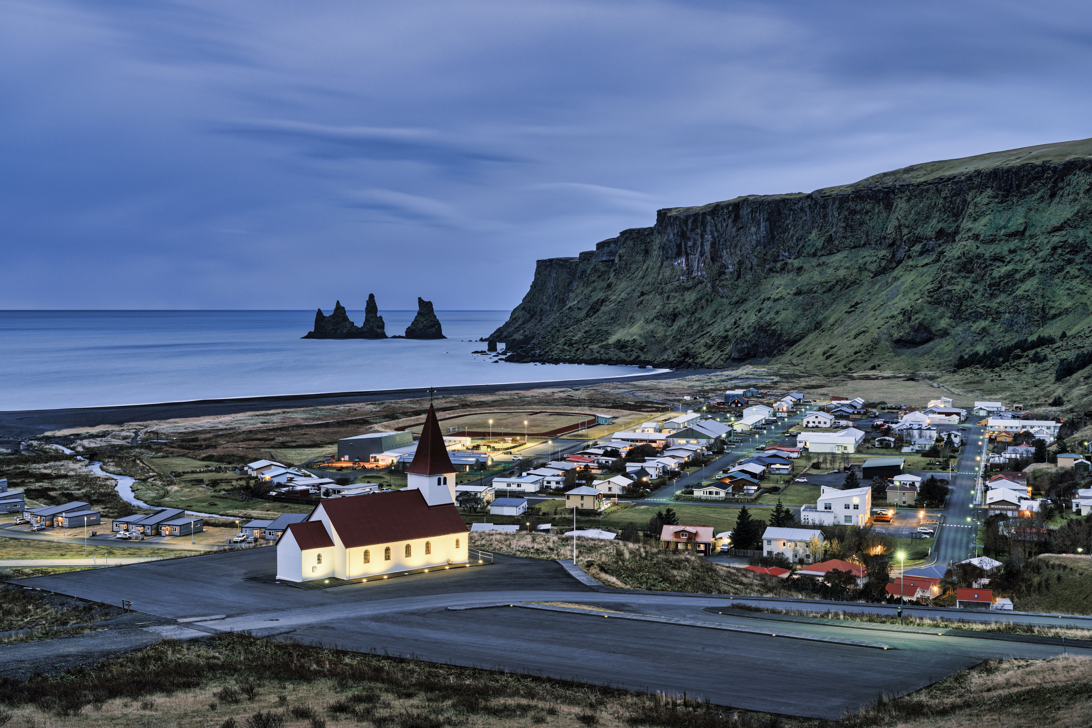 Cityscape with Reynisdrangar rock formations in the background in Vík, Iceland